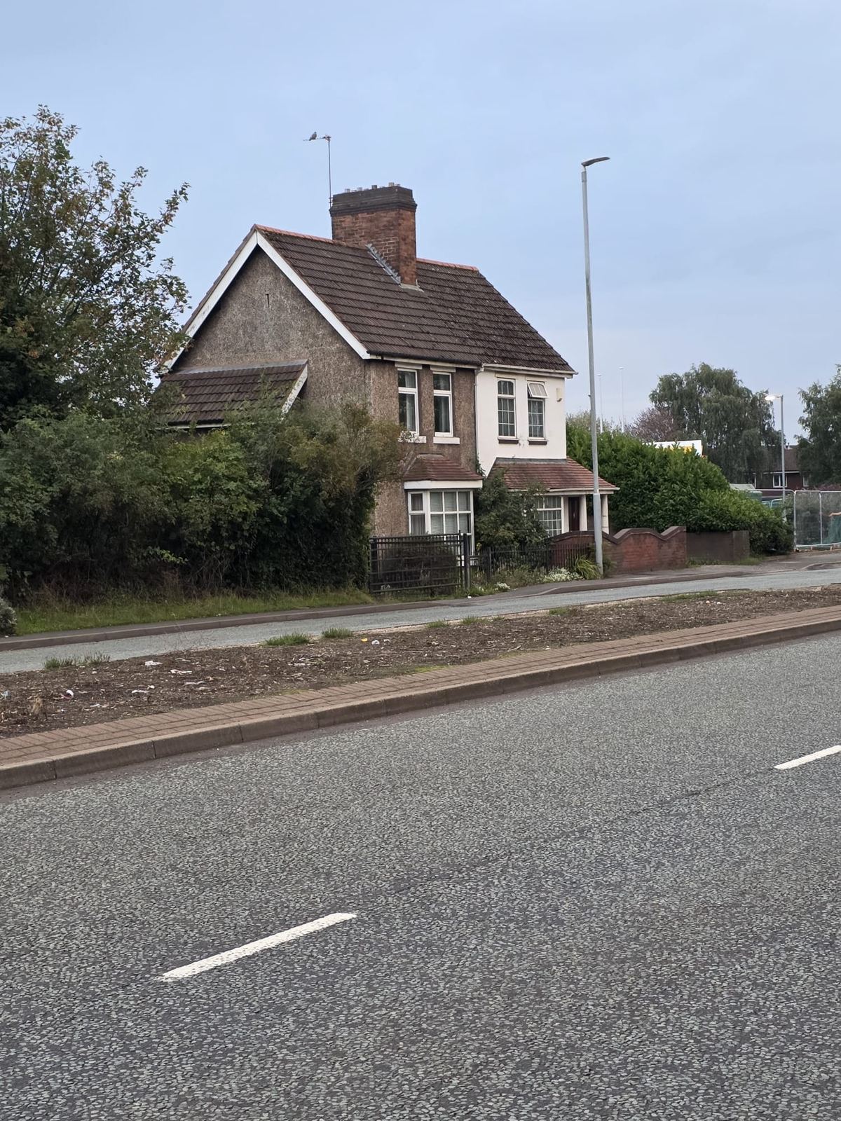 Roadside House Behind a Hedge