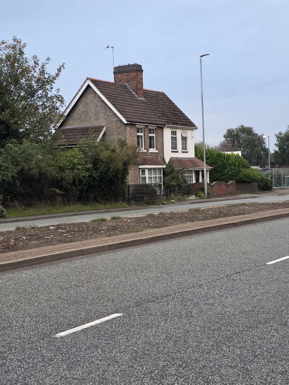 Roadside House Behind a Hedge